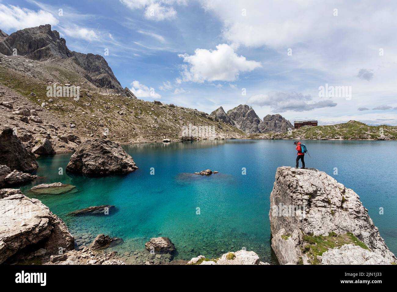 Donna escursionista sulla roccia sopra il lago alpino Laserzsee, sopra la città di Lienz, nelle Dolomiti di Lienz, Tirolo Orientale, Austria, Europa Foto Stock