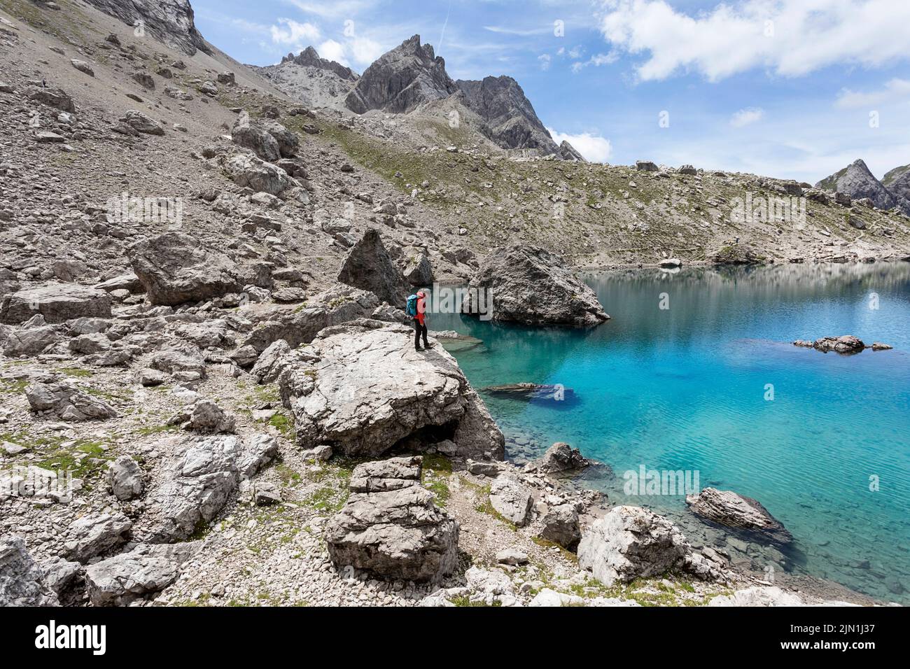 Donna escursionista che guarda il lago alpino Laserzsee, sopra la città di Lienz, nelle Dolomiti di Lienz, Tirolo Orientale, Austria, Europa Foto Stock