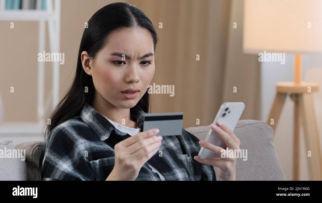 Arrabbiato puzzled donna asiatica prova a pagare con e-bank app servizio online ha problema con carta di credito bloccato limite finanziario non attivato per internet Foto Stock