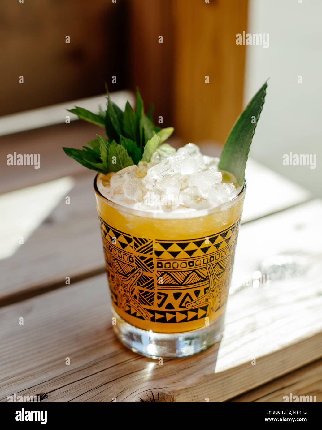 Cocktail ghiacciato siede su portico di legno in una calda giornata estiva Foto Stock