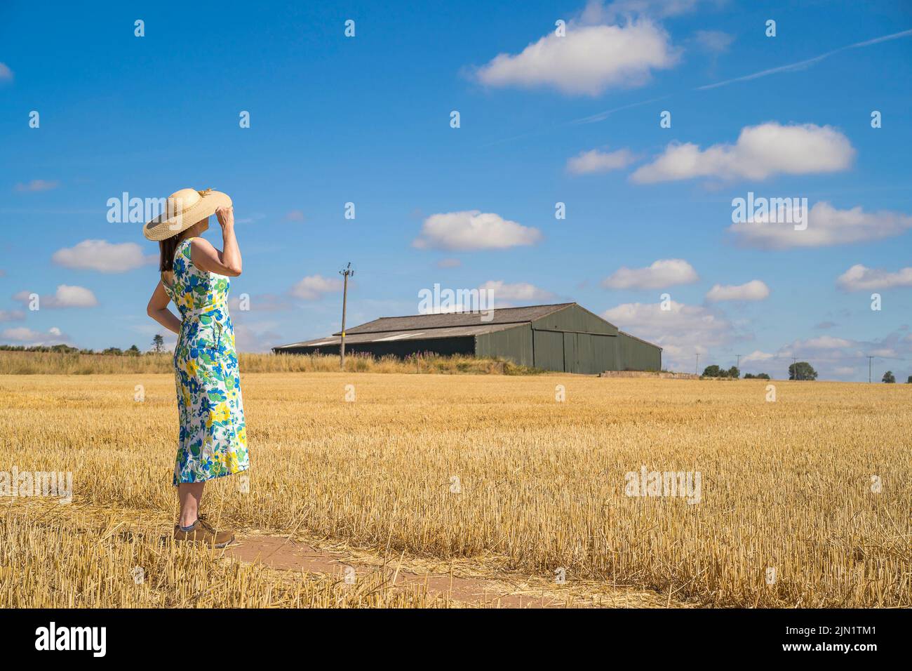 Kidderminster, Regno Unito. 8th Agosto 2022. Tempo del Regno Unito: Con le temperature alle stelle e il calore ondeggiante in tutto il Regno Unito oggi, l'unico modo per ottenere un po' di ombra in più sembra essere sotto la copertura di un cappello di paglia a bordo largo se si desidera uscire per una passeggiata nel paese! Con il tempo buono come questo, Miss T, un insegnante del Worcestershire, sta godendo completamente la sua staycation di estate! Credit: Lee Hudson/Alamy Live News Foto Stock