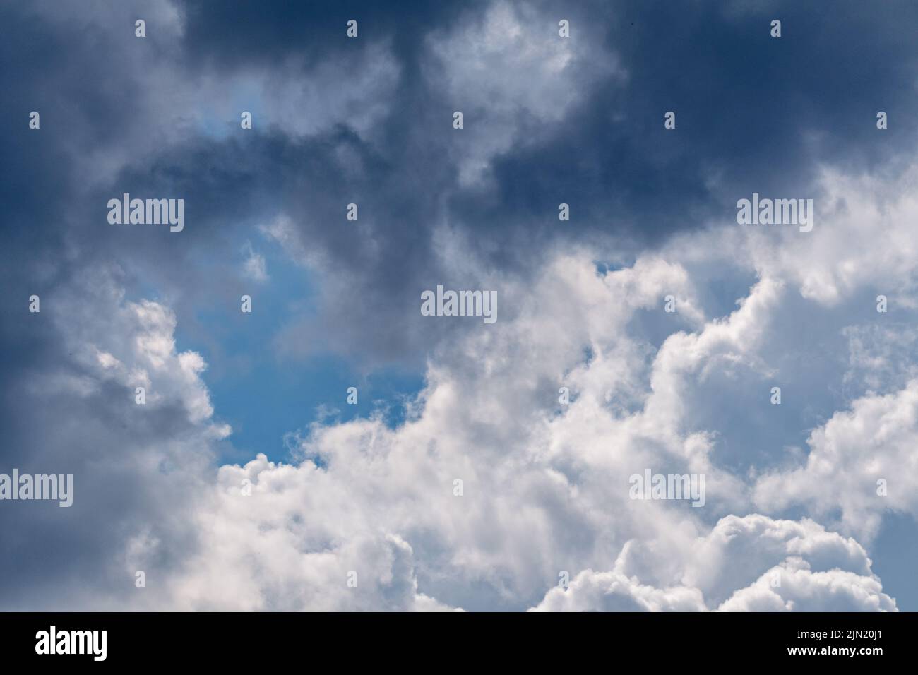 Alte nuvole bianche e grigie epiche su cielo blu. Cielo sfondo nuvoloso Foto Stock