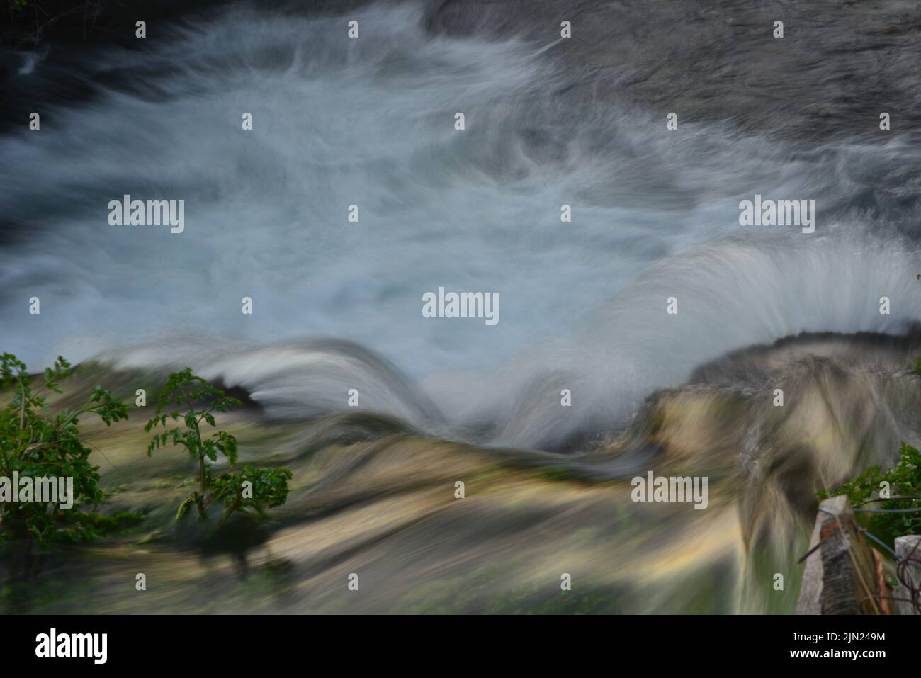 Onde d'acqua che scorrono su rocce Foto Stock