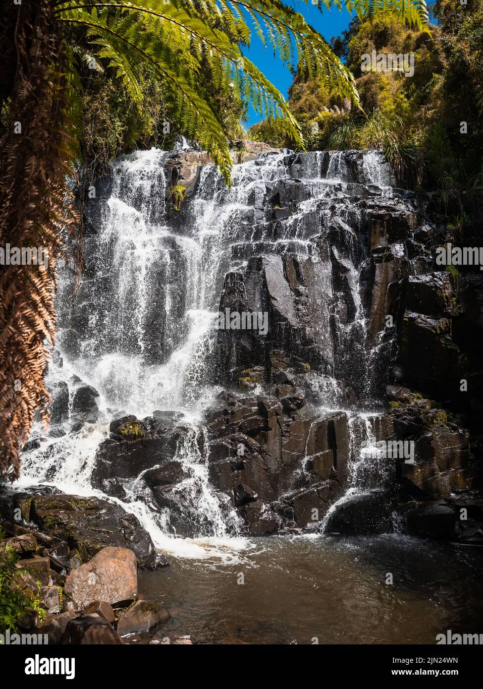 Famosa cascata turistica con piante tropicali nelle giornate di sole Foto Stock