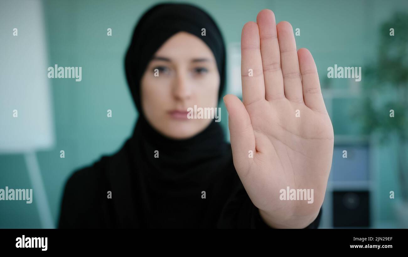 Ritratto grave frustrato arrabbiato arabo musulmano musulmana ragazza islamica in nero hijab sconvolto donna guardando la fotocamera tenendo la mano di fronte vietato gesto Foto Stock