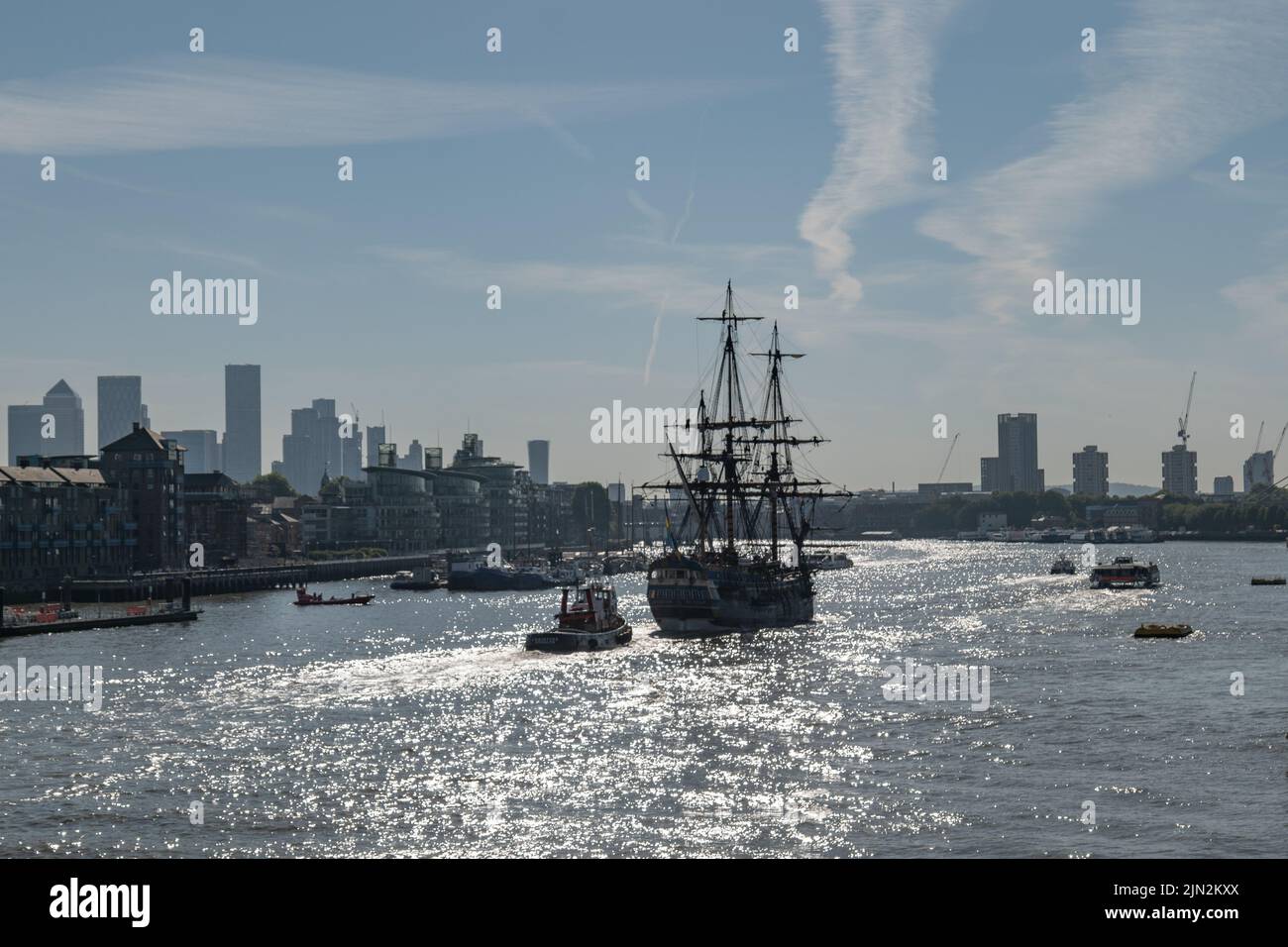 La nave alta Götheborg di Svezia si avvicina al suo ormeggio a South Dock, Canary Wharf, dopo aver attraversato Tower Bridge, scortato dal rimorchiatore Christine. Foto Stock