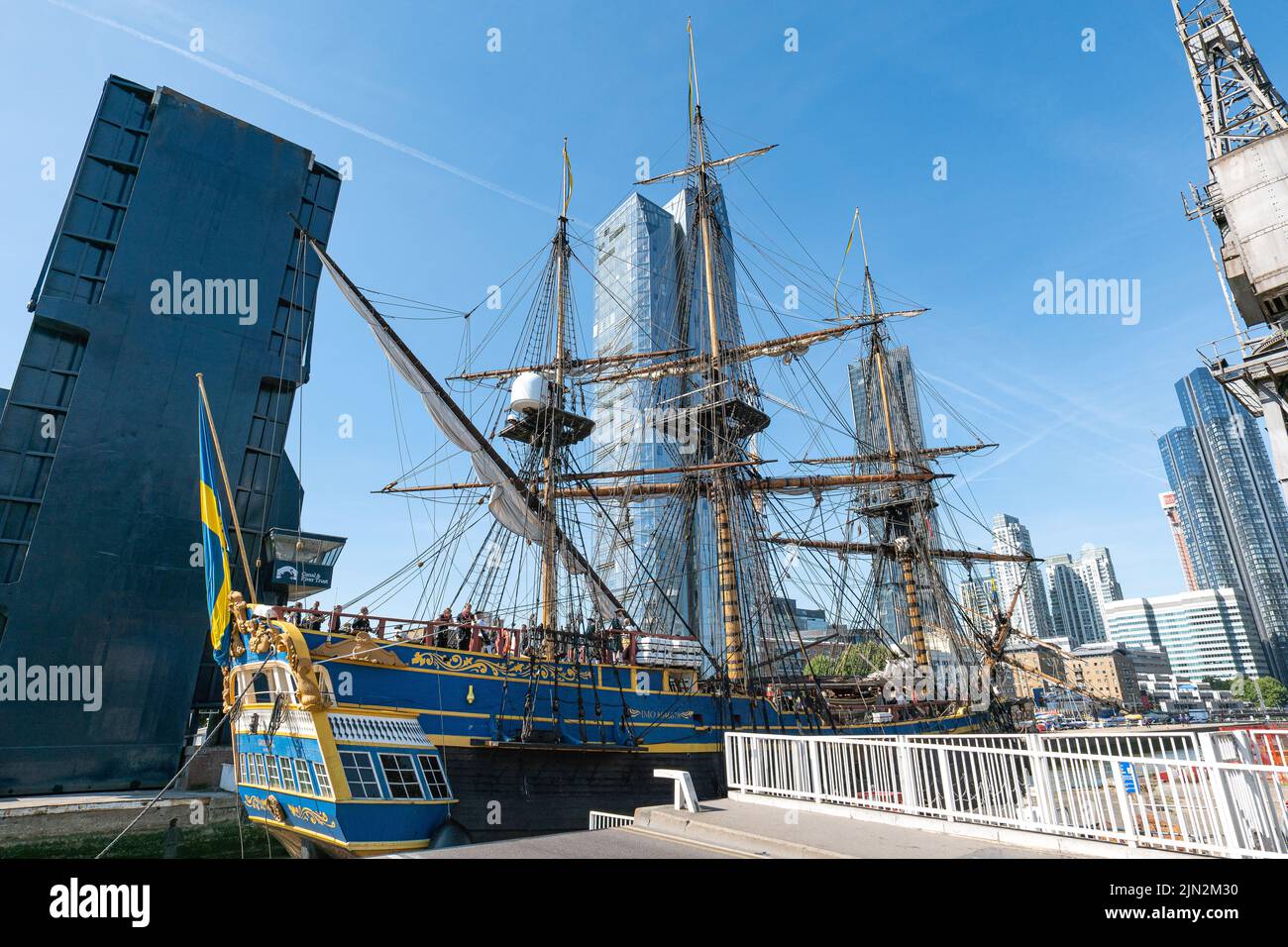 Nave alta svedese Goteborg (Götheborg di Svezia) che passa sotto un ponte blu sopraelevato per ormeggi a Thames Quay nel molo sud di Canary Wharf. Foto Stock