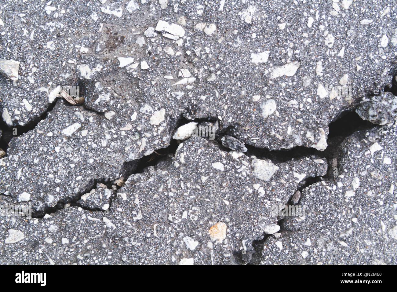 Muro di pietra con crepe profonde. Rompere il terreno. Siccità e conseguenze. Terra asciutta incrinata. Primo piano della texture. Foto Stock