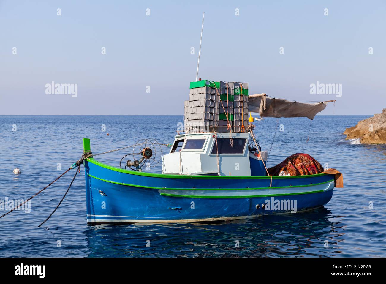 Piccola barca da pesca è ancorata in porto in una giornata di sole Foto Stock