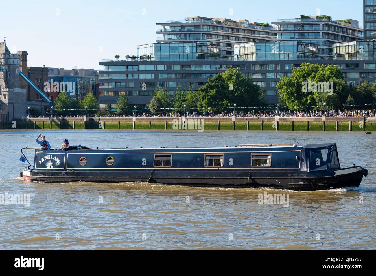 Barca stretta Jabulani passando lungo il Tamigi, Londra, Regno Unito, passando South Bank e un Tower Bridge Foto Stock