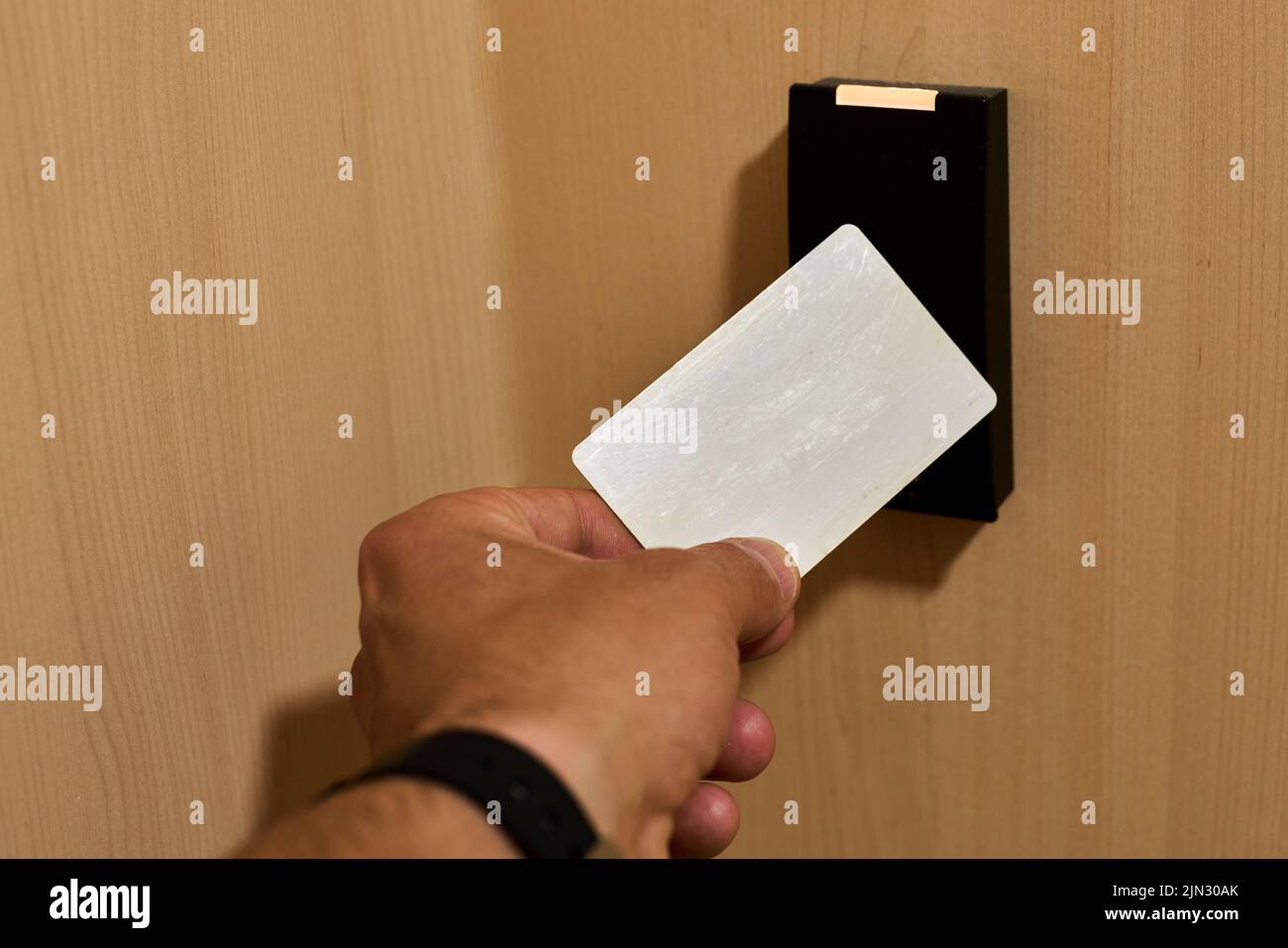 Avvicinare una scheda a un lettore rfid per aprire una porta di sicurezza Foto Stock