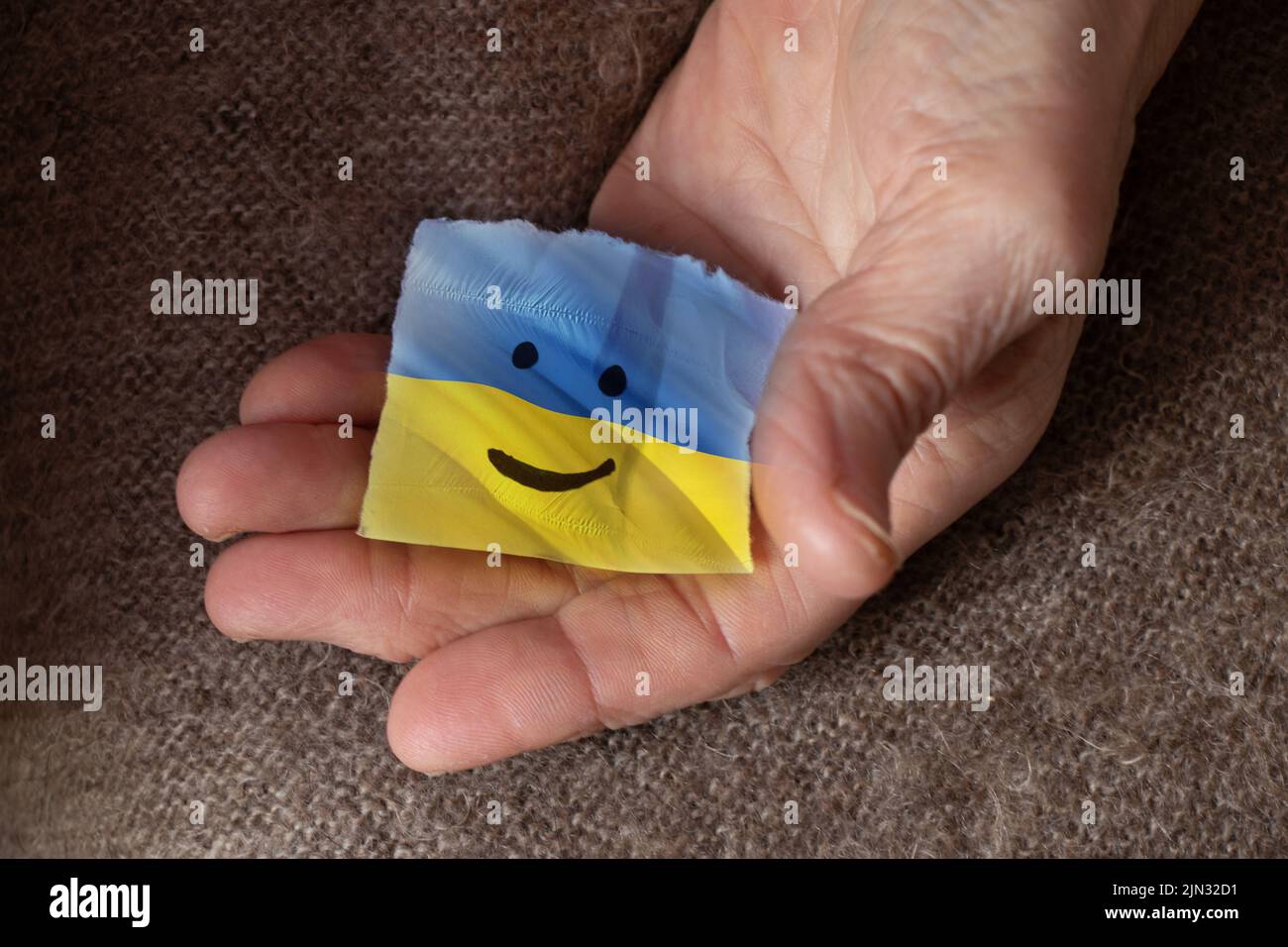 La bandiera dell'Ucraina è giallo-blu su carta con un sorriso disegnato in mano di una donna, la gioia e la bandiera dell'Ucraina, patriota, la pace Foto Stock