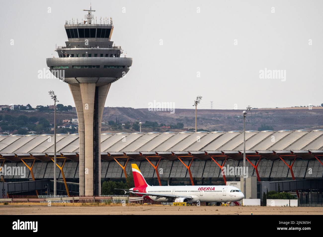 Un aereo Iberia visto sulla pista di Adolfo Suarez Madrid Barajas Aeroporto passando per la torre di controllo del traffico aereo. Foto Stock