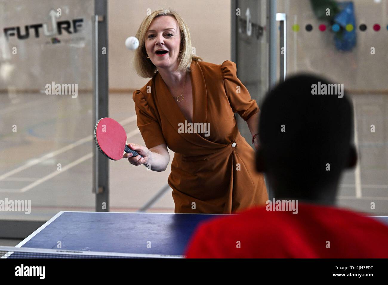 Il candidato alla leadership del partito conservatore britannico Liz Truss gioca a ping pong durante una visita alla Future Youth zone di Londra, in Gran Bretagna, il 8 agosto 2022. REUTERS/Dylan Martinez/Pool Foto Stock