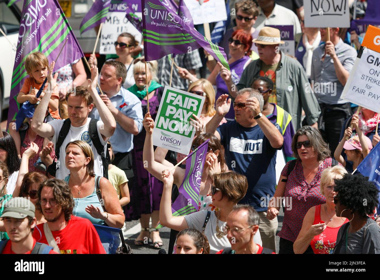I manifestanti vengono raffigurati con bandiere e cartelli sindacali durante uno sciopero sindacale del settore pubblico e un raduno a Bristol. 10th luglio, 2014 Foto Stock