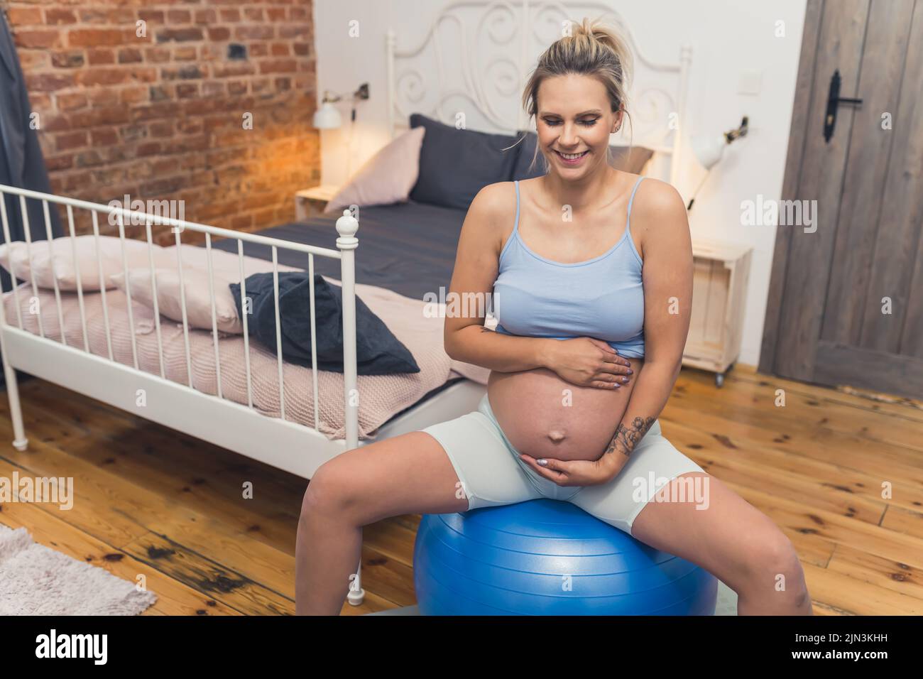 donna incinta felice facendo esercizi di rilassamento con un fitness pilates palla a casa, sano concetto di gravidanza. Foto di alta qualità Foto Stock