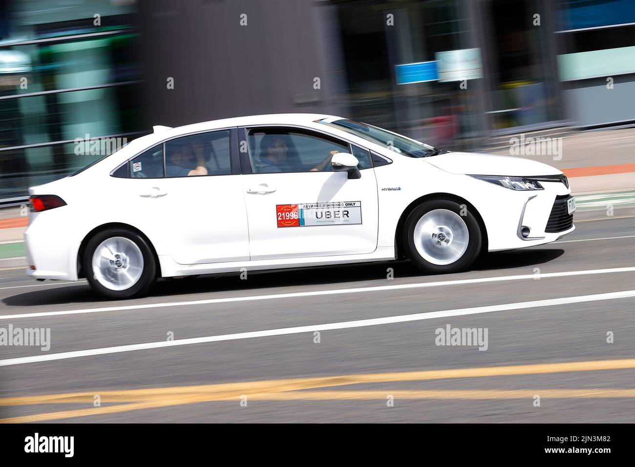 Un taxi privato a noleggio Uber, visto passare attraverso il centro di Leeds con i passeggeri. Foto Stock