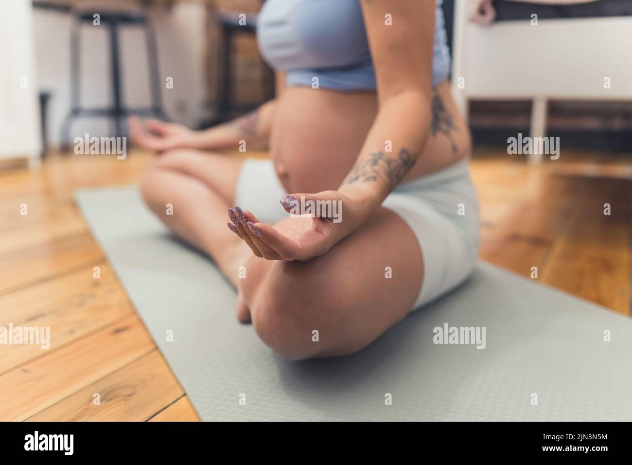 donna incinta meditante a casa. Foto di alta qualità Foto Stock