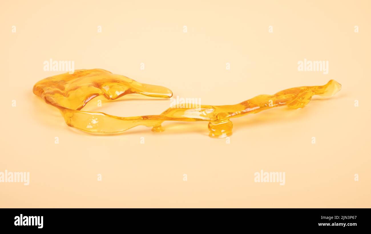 piace golden dab concentrato di cera di cannabis primo piano su sfondo giallo, resina di marijuana. Foto Stock