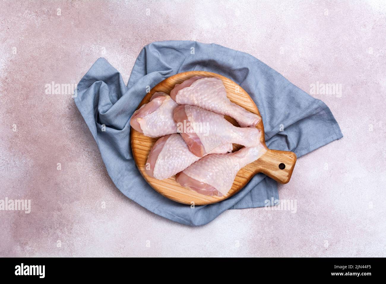 Bastoncini di pollo crudi su un asse di legno. Carne di pollo fresca su un tagliere. Vista dall'alto. Foto Stock Bastoncini di pollo crudi su un asse di legno. Carne di pollo fresca su un tagliere. Vista dall'alto. Foto Stock