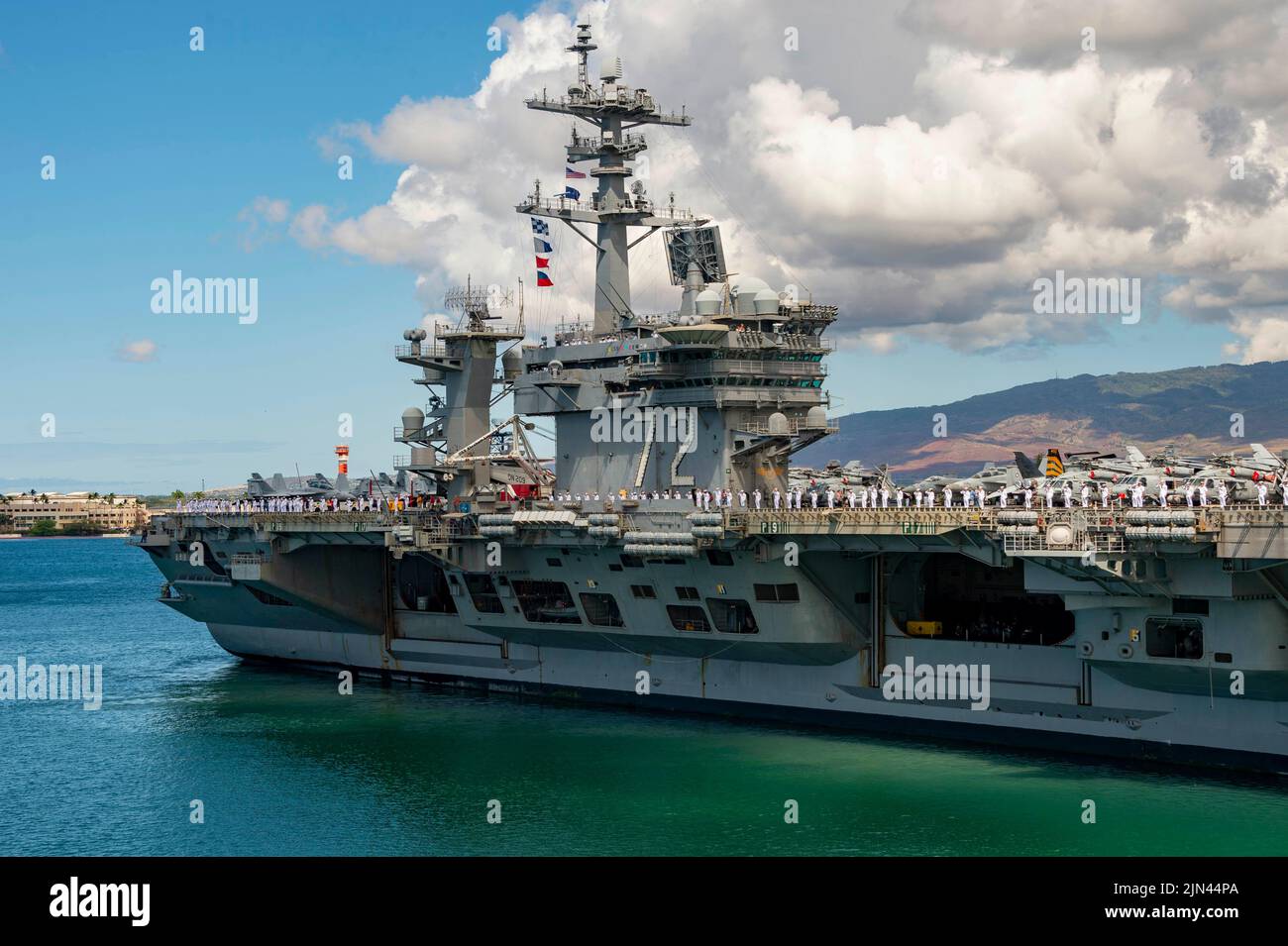 OCEANO PACIFICO (agosto 5, 2022) marinai assegnati alla portaerei a propulsione nucleare USS Abraham Lincoln (CVN 72) di classe Nimitz rendono onore alla USS Arizona Memorial, come visto dalla nave d'assalto anfibio di classe Wasp USS Essex (LHD 2), 5 agosto 2022. Essex sta conducendo operazioni di routine nella flotta USA 3rd. (STATI UNITI Foto Navy di Mass Communication Specialist 3rd Classe Christina Himes) Foto Stock