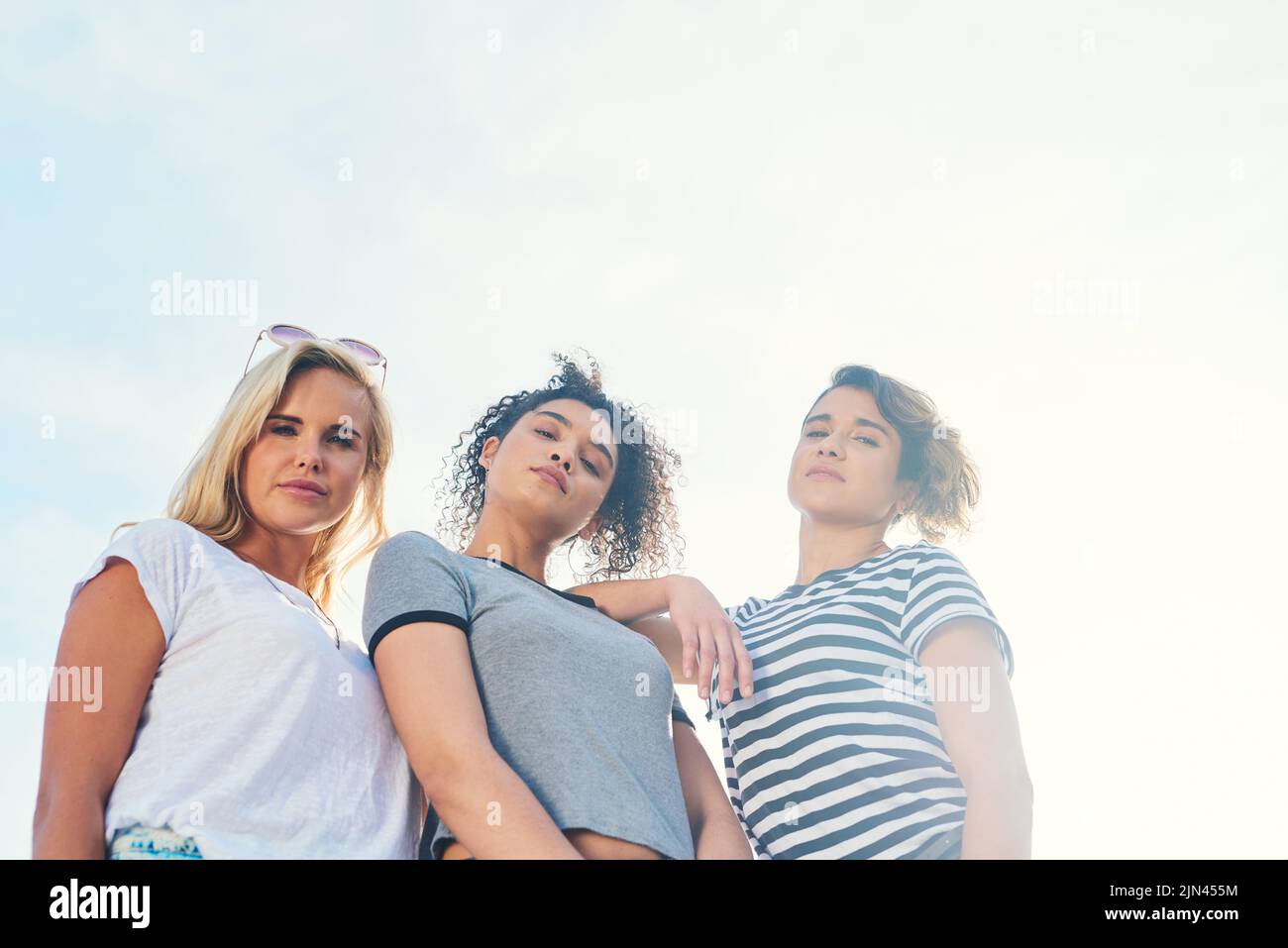 Noi portiamo il calore: Tre amici che trascorrono la giornata insieme in una giornata di sole. Foto Stock