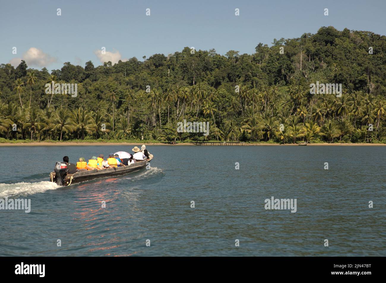 Una barca che trasporta i turisti sta navigando sull'acqua al largo della costa dell'isola di Seram, vicino al villaggio morale in Seram Utara Barat, Maluku Tengah, Maluku, Indonesia. Foto Stock