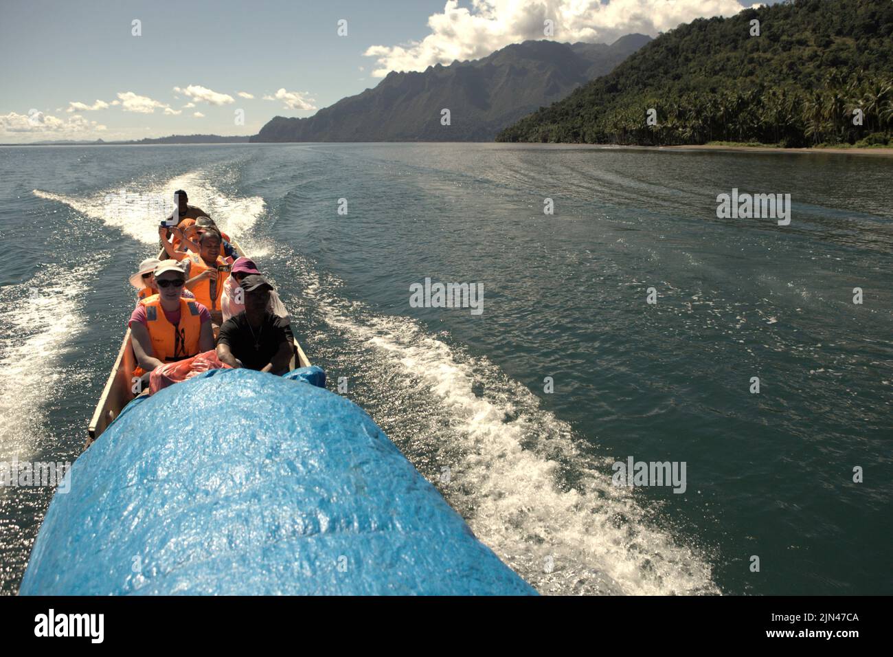 Una barca che trasporta i turisti sta navigando sull'acqua al largo della costa dell'isola di Seram, vicino al villaggio morale in Seram Utara Barat, Maluku Tengah, Maluku, Indonesia. Foto Stock