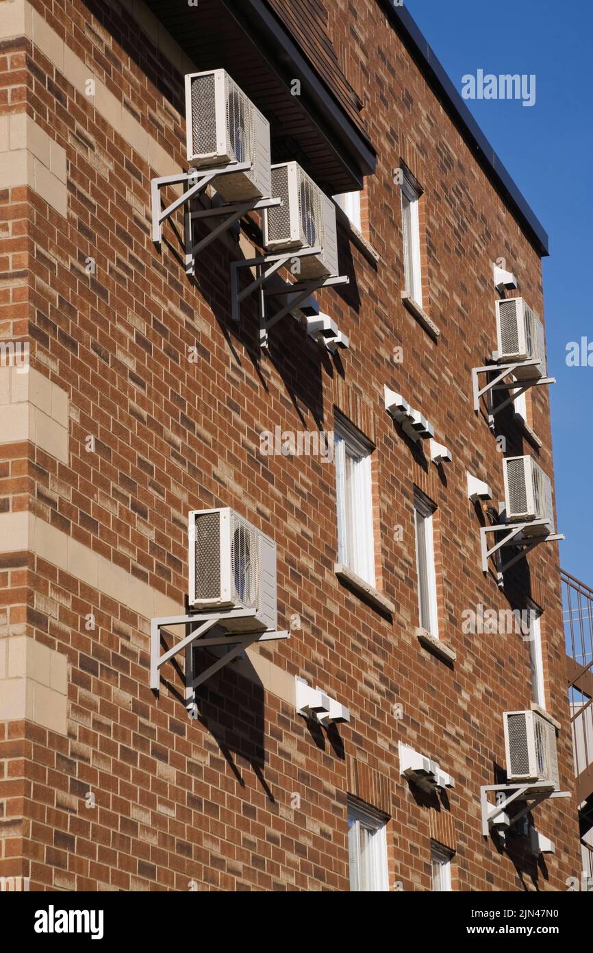 Gruppi pompa Thermo e sfiati di scarico dell'essiccatore sulla parete esterna dell'edificio condominiale. Foto Stock