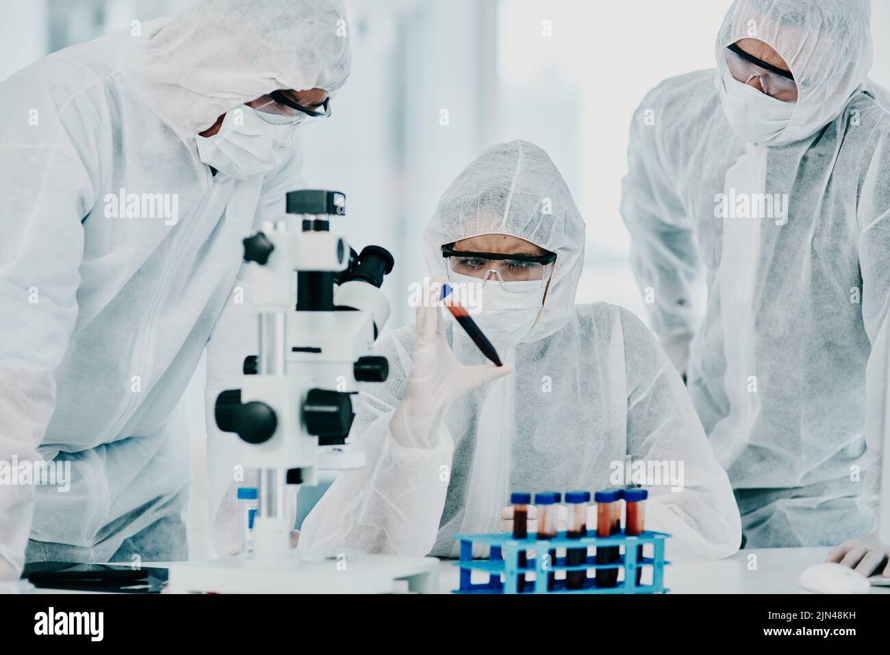 Gruppo di scienziati che conducono ricerche mediche in tute e guanti protettivi per la cura del coronavirus in laboratorio. Ricercatori che conducono Foto Stock