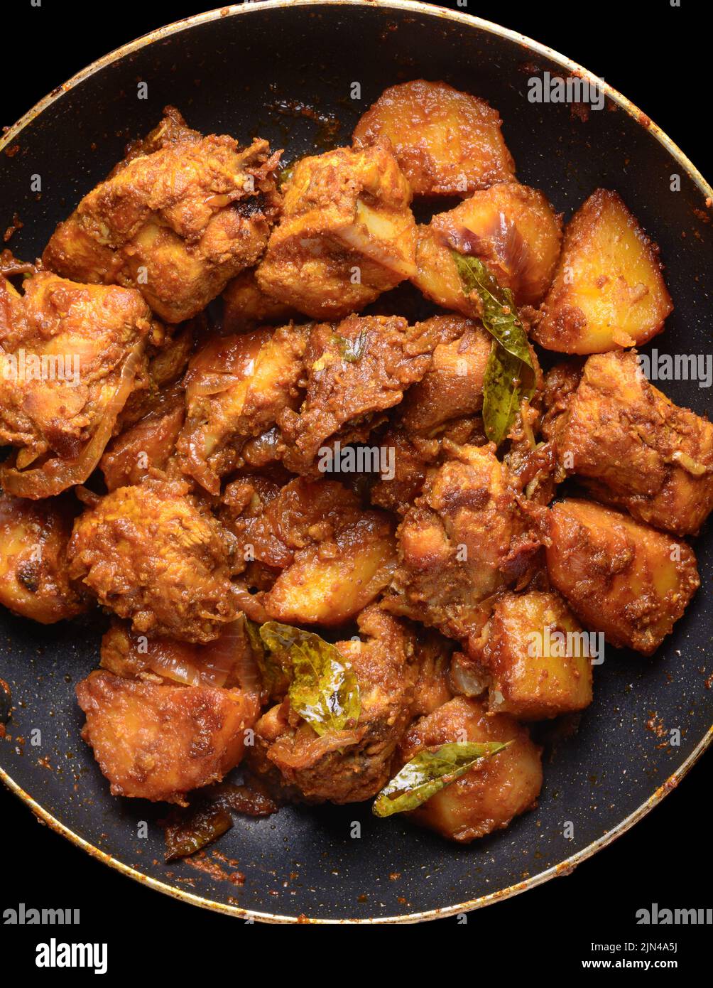 primo piano di curry di pollo rosso, piatto temprato di cremoso ma piccante, aromatico e mescolato con patate, preso direttamente dall'alto Foto Stock