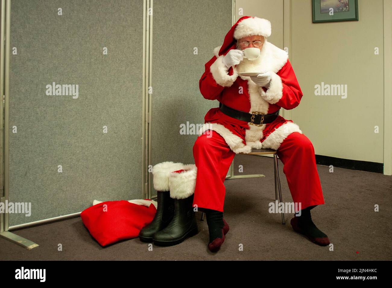 Un grande magazzino Santa che ha una tazza di tè dopo un lungo turno in un centro commerciale a Hobart, Tasmania, Australia durante il periodo di shopping pre-Natale Foto Stock