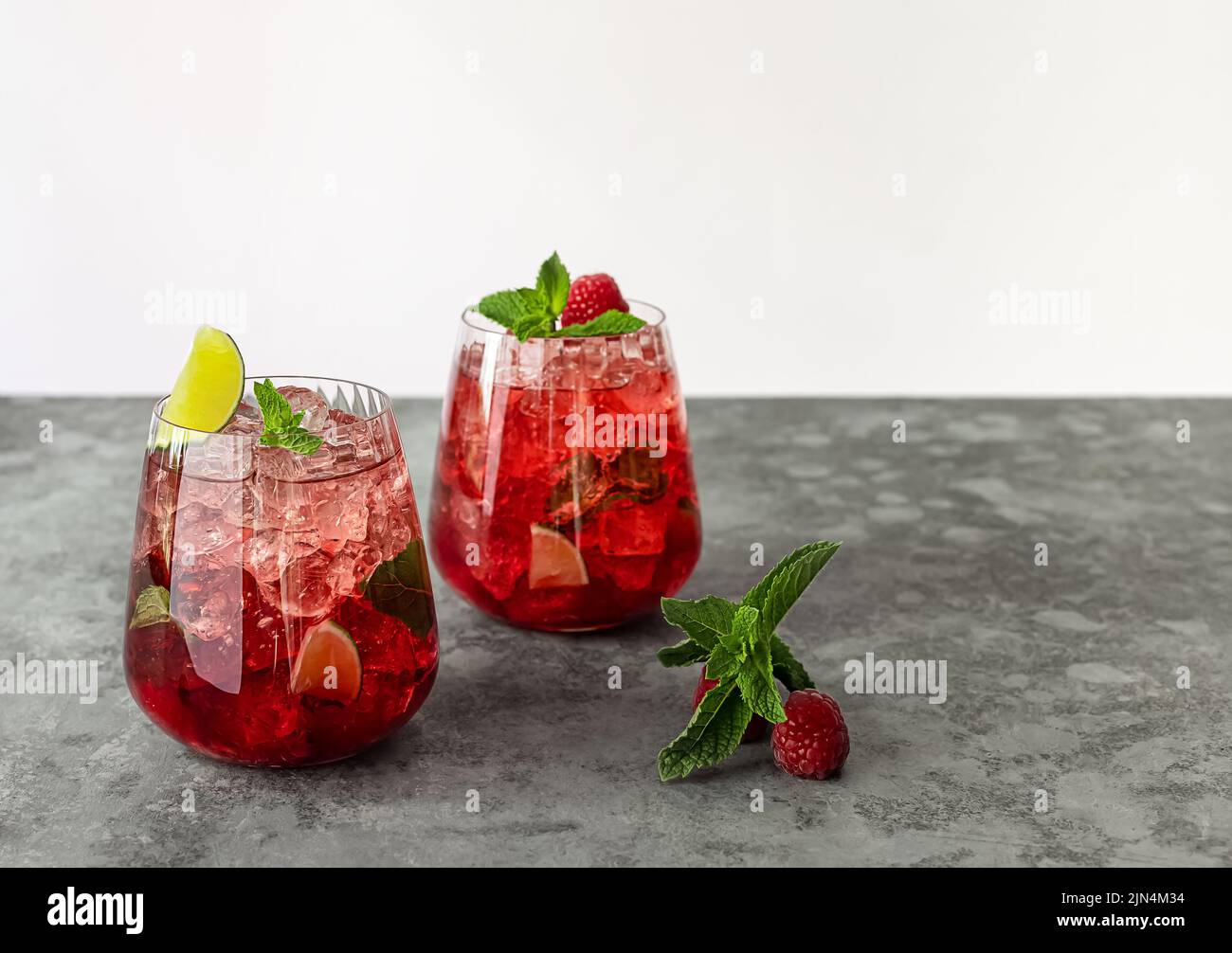 Limonata estiva fresca con lampone, calce, acqua soda e ghiaccio in bicchieri. Foto Stock