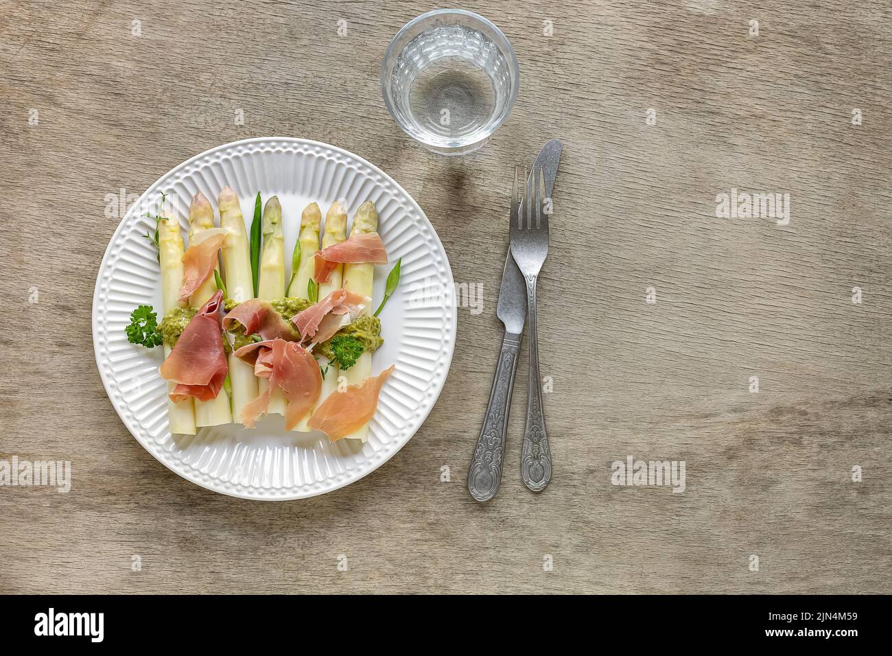 Asparagi bianchi con pesto e prosciutto italiano. Deliziosa cena per la stagione primaverile. Foto Stock