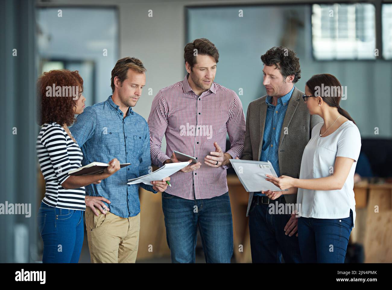 Parlare, pianificare o incontrare un gruppo di colleghi che parla di idee, discute di strategia sul lavoro cartaceo e collaborazioni. Uomo d'affari che spiega Foto Stock