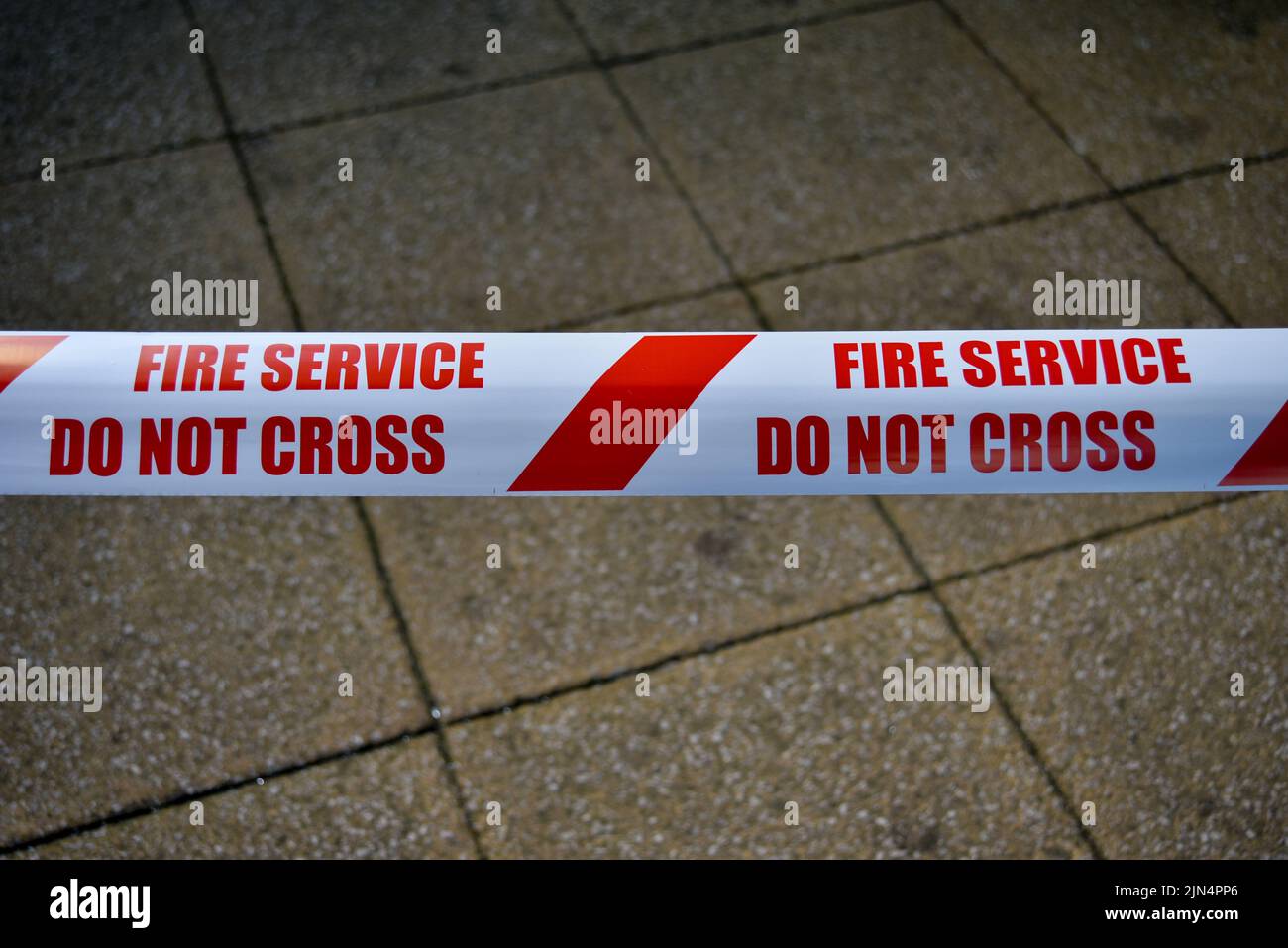 Nastro di sicurezza per i servizi antincendio a strisce rosse e bianche, con un avvertimento di non incrociare. Foto Stock