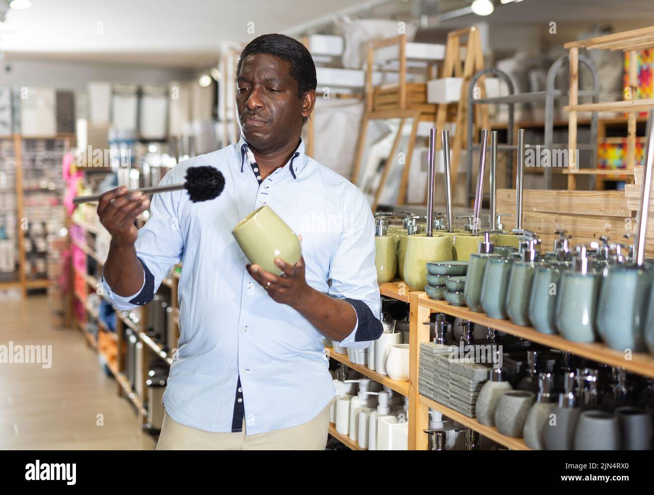 African American shopper scelta accessori bagno in negozio Foto Stock