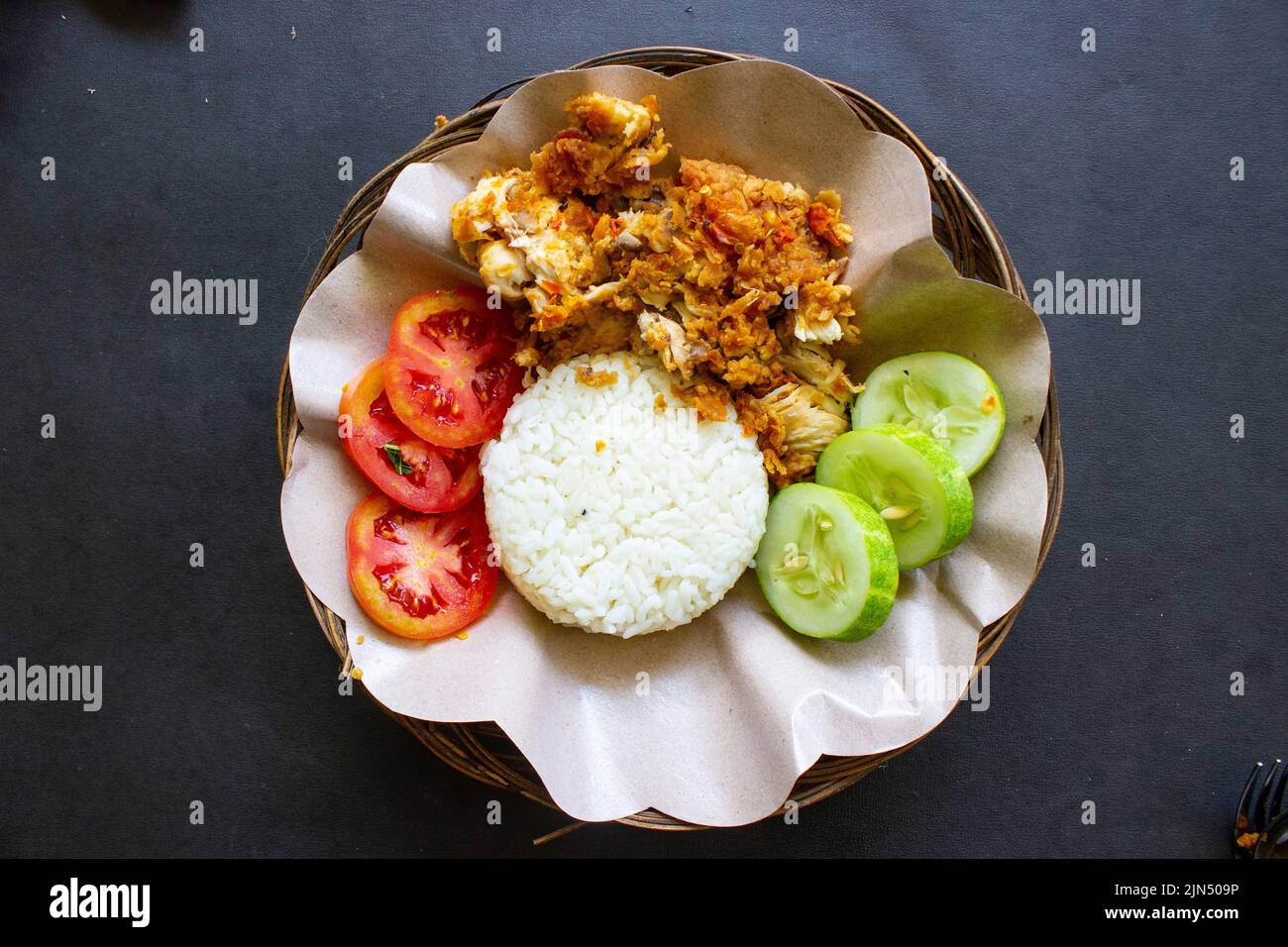 l'ayam geprek o la schiacciata di pollo o il pollo schiacciato è cibo indonesiano a base di pollo fritto preparato con gusto di peperoncino e aglio e servito con Foto Stock