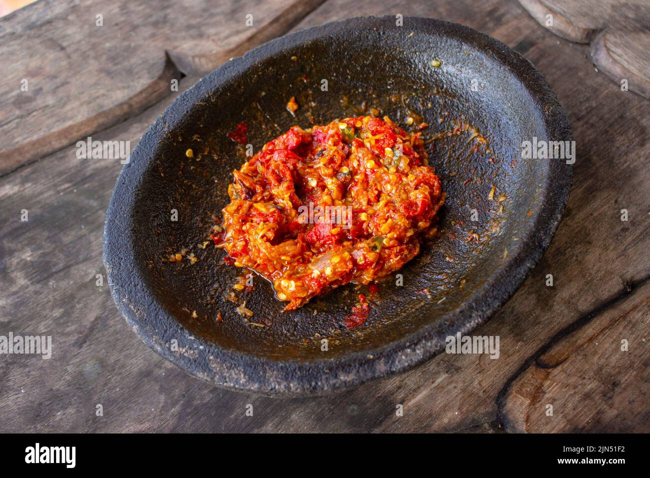 sambal fresco servito su mortaio di pietra (cobek). sambal è salsa tradizionale dall'indonesia fatta dal peperoncino Foto Stock