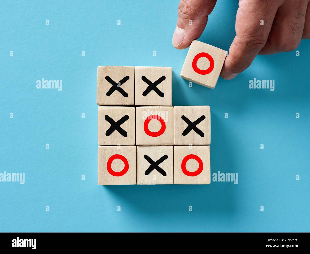 Mano mettendo cubo di legno con o lettera e vincere la x o o tic tac gioco punta. Strategia vincente per il business. Foto Stock