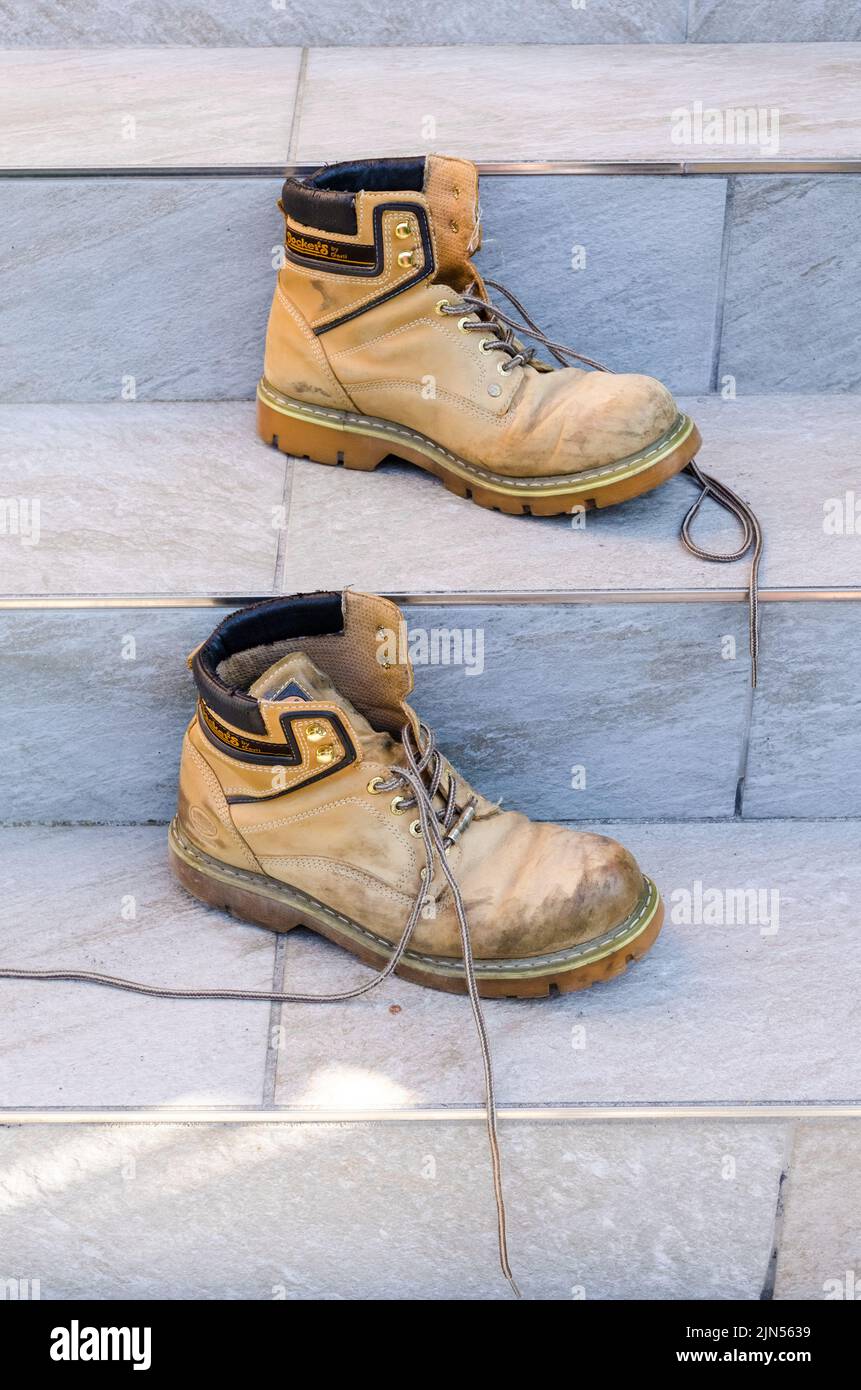 Paio di scarponi da lavoro o da trekking sporchi sulle scale Foto stock -  Alamy