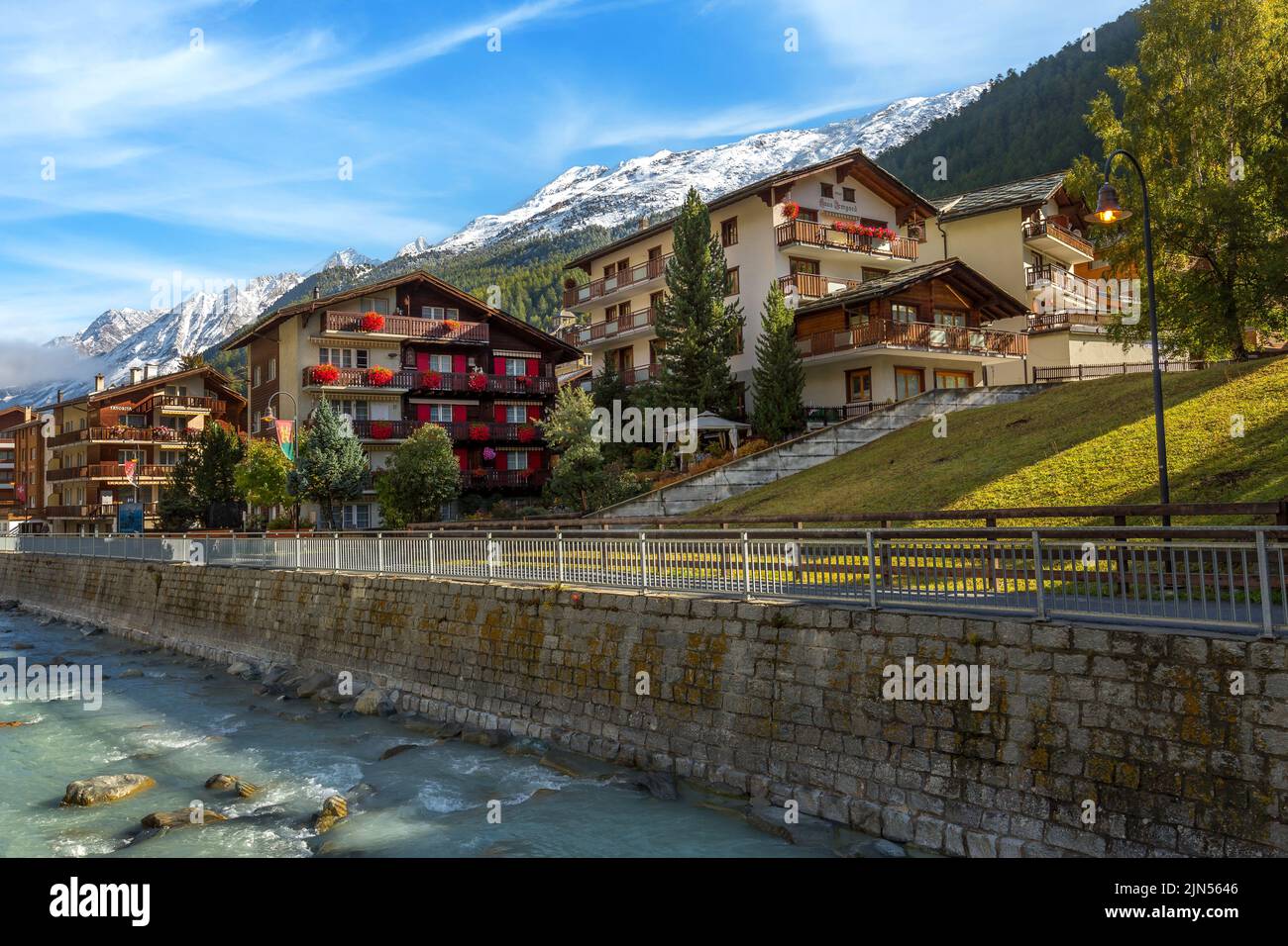 Zermatt, Svizzera - 7 ottobre 2019: Vista sulla strada della città nella famosa stazione sciistica delle Alpi svizzere, fiume, vette innevate Foto Stock