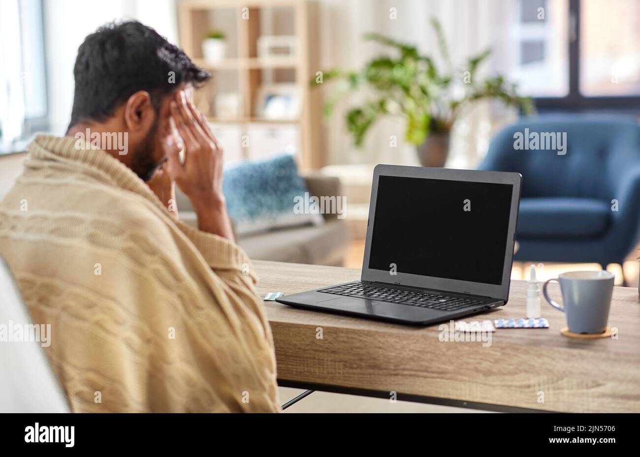 uomo indiano malato che ha videochiamata sul laptop Foto Stock