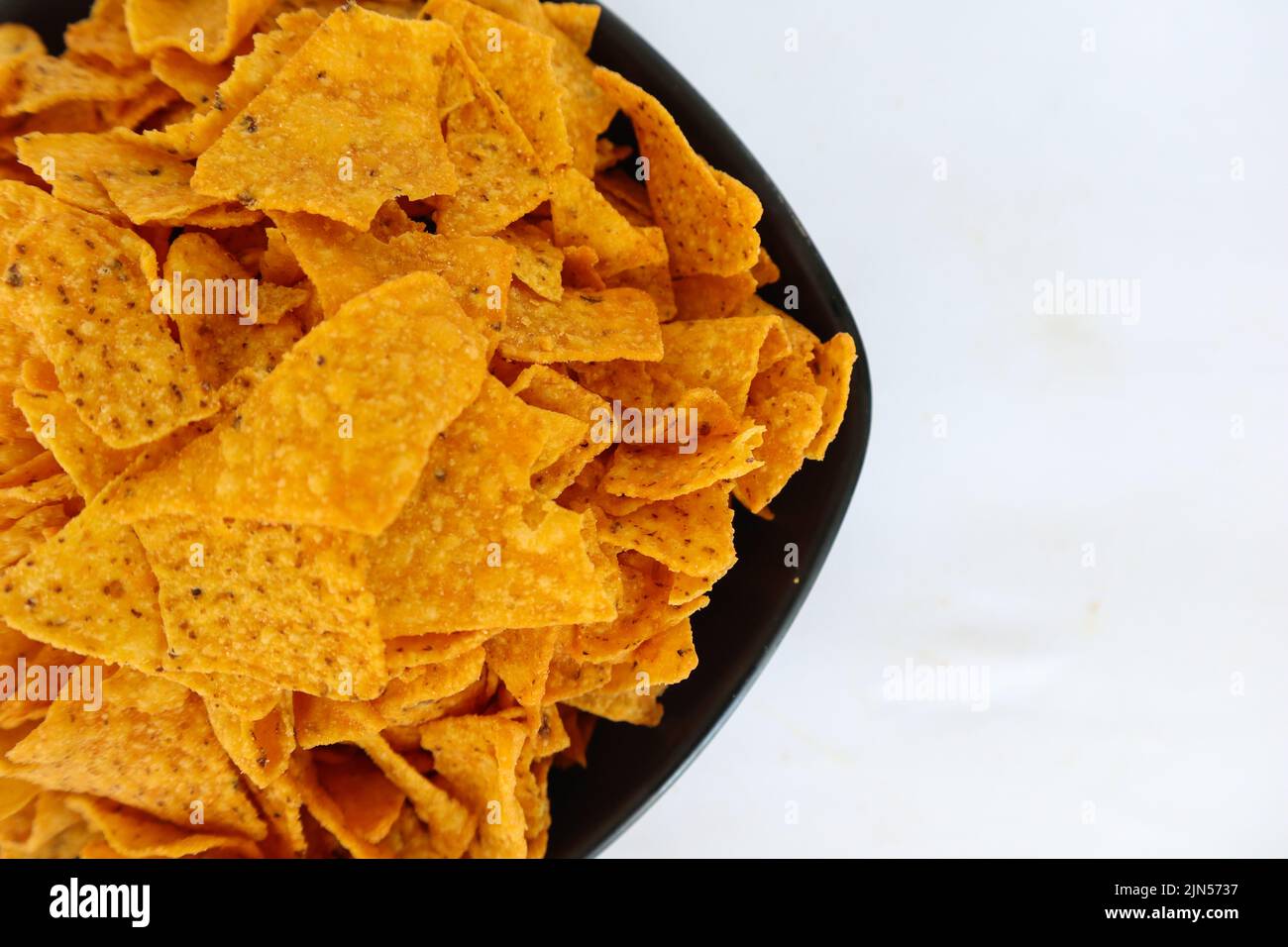 il chip di tortilla è patatine di mais o nachos chiamata, servito in ciotola, su sfondo nero fatto di mais Foto Stock