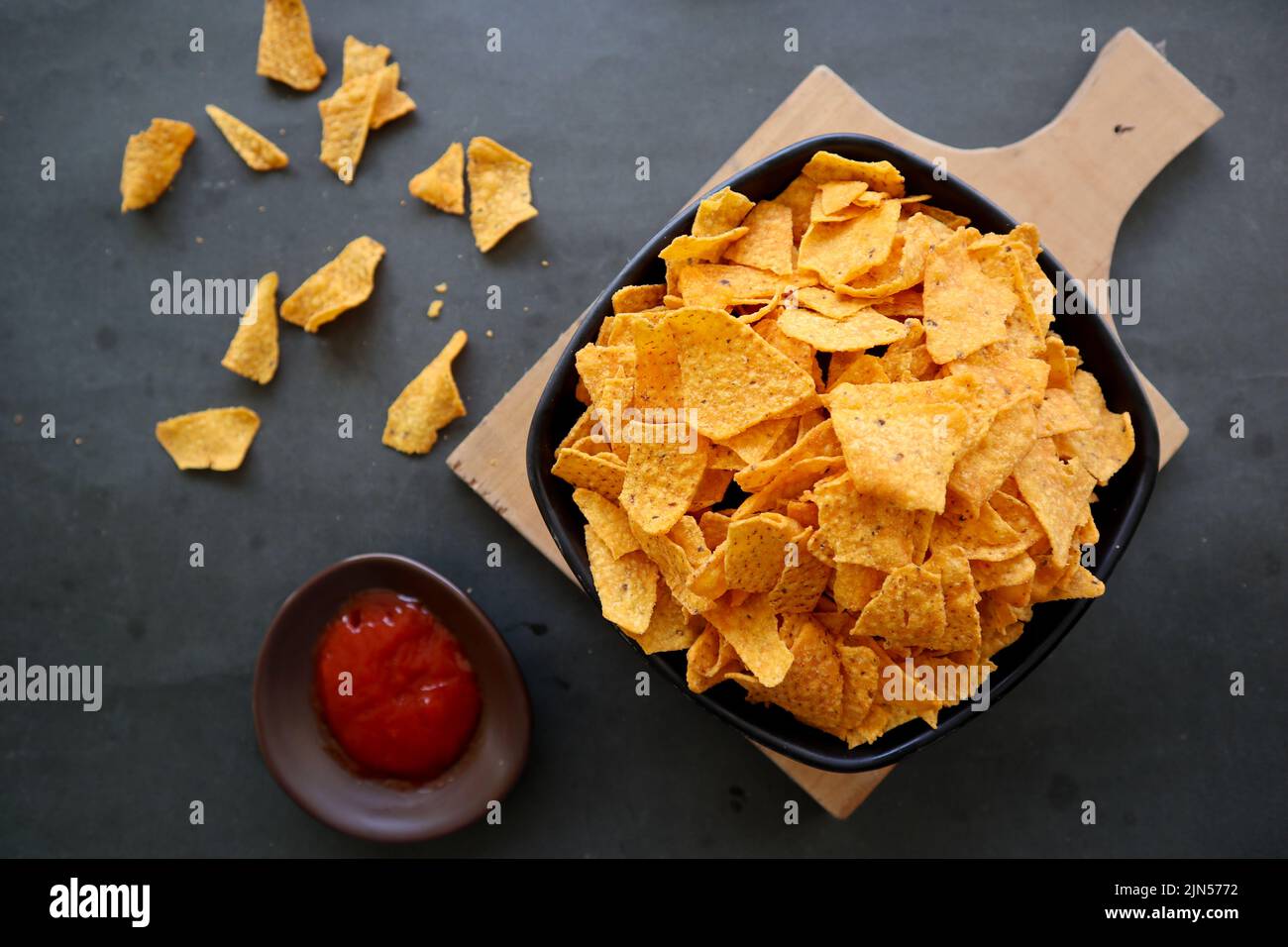 il chip di tortilla è patatine di mais o nachos chiamata, servito in ciotola, su sfondo nero fatto di mais Foto Stock