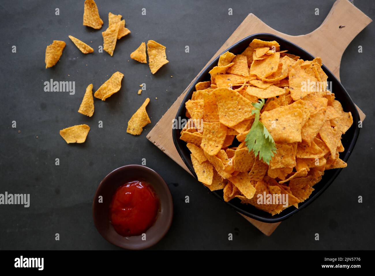 il chip di tortilla è patatine di mais o nachos chiamata, servito in ciotola, su sfondo nero fatto di mais Foto Stock