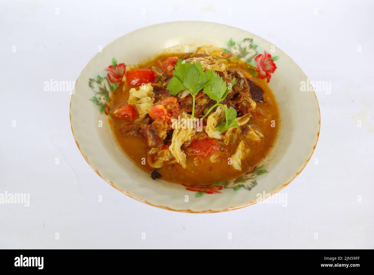 'Capra Curry o gulai kambing, cibo da asia. Delizioso curry di carne di capra servito in un bowl.served con pomodoro, condimento, sedano e cavolo' Foto Stock