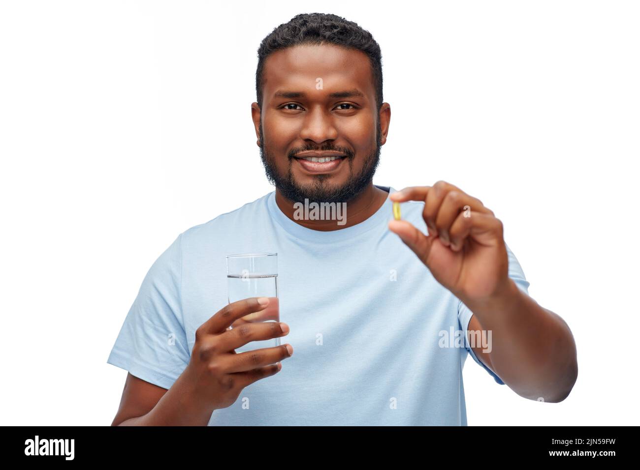 uomo afroamericano con pillola e bicchiere d'acqua Foto Stock