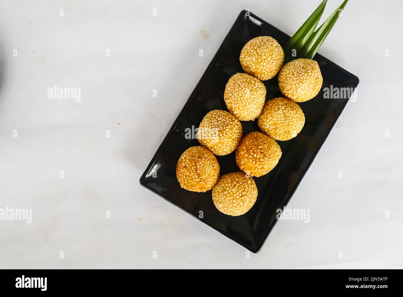 onde-onde o palla di sesamo o Jian Dui è una pasta fritta cinese fatta con farina di riso glutinoso e rivestita con semi di sesamo ripieni di pasta di fagioli. Foto Stock