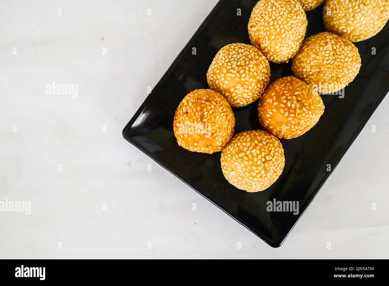 onde-onde o palla di sesamo o Jian Dui è una pasta fritta cinese fatta con farina di riso glutinoso e rivestita con semi di sesamo ripieni di pasta di fagioli. Foto Stock